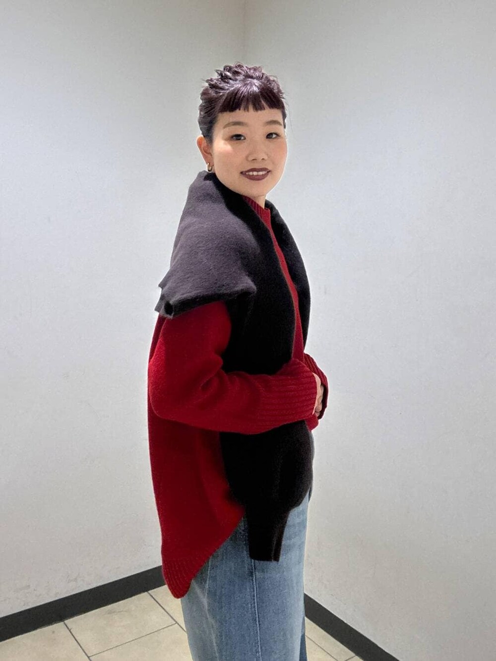 ブルー系のデニムパンツ、ブラック系のブーツ、レッド系のニット/セーターを着用したレディースの冬コーディネートの7枚目の写真