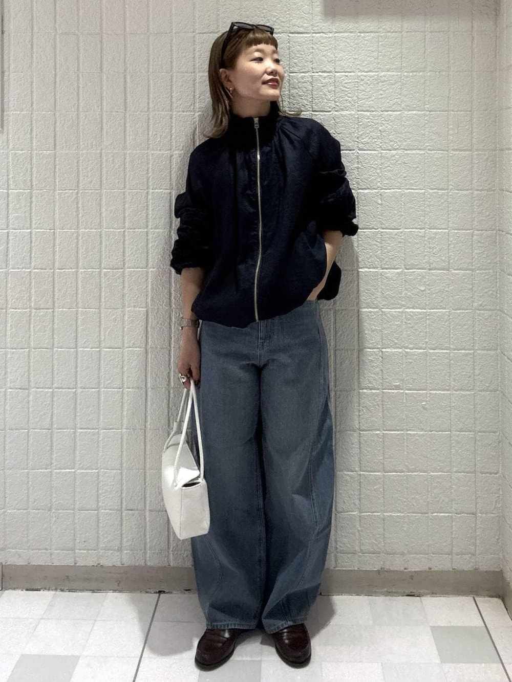 ブルー系のデニムパンツ、ホワイト系のショルダーバッグ、ブルー系のブルゾンを着用したレディースの春コーディネートの5枚目の写真