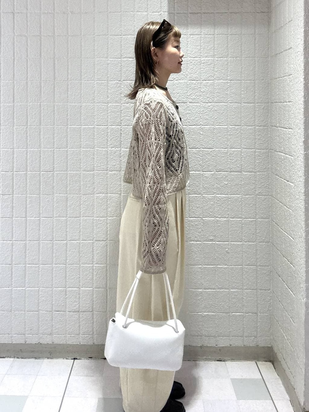 ホワイト系のショルダーバッグ、ベージュ系のカーディガン/ボレロ、ブラウン系のサングラスを着用したレディースの春コーディネートの3枚目の写真