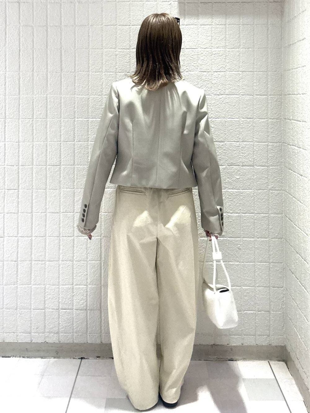 ホワイト系のショルダーバッグ、ベージュ系のカーディガン/ボレロ、ベージュ系のノーカラージャケットを着用したレディースの春コーディネートの4枚目の写真