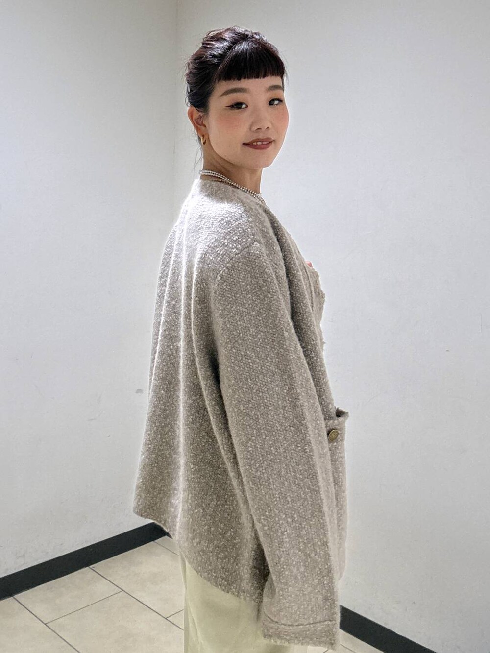 ベージュ系のデニムパンツ、ブラック系のブーツ、ホワイト系のニット/セーターを着用したレディースの秋コーディネートの6枚目の写真