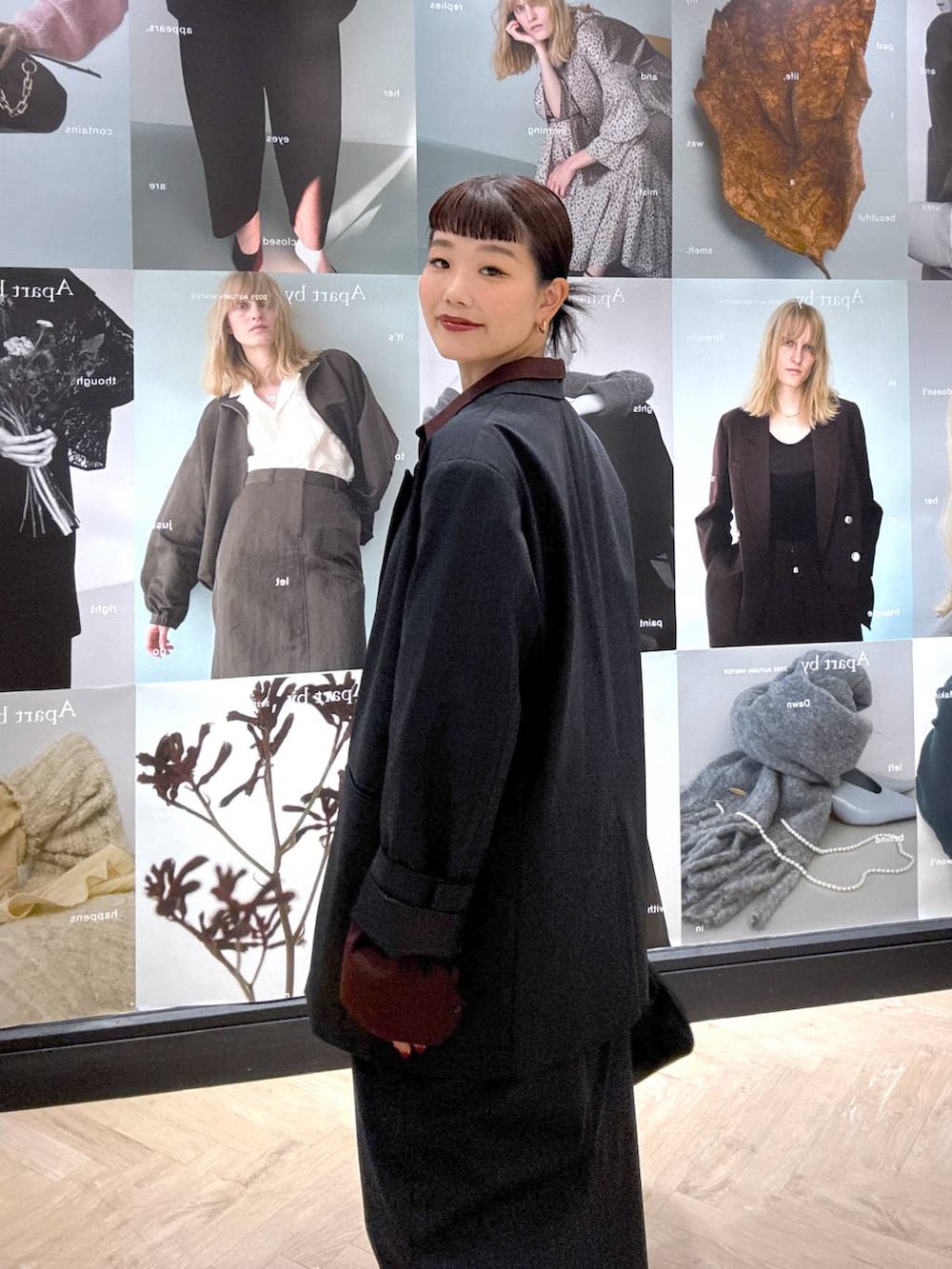 ブラック系のショルダーバッグ、グレー系のスカート、グレー系のテーラードジャケットを着用したレディースの秋コーディネートの7枚目の写真