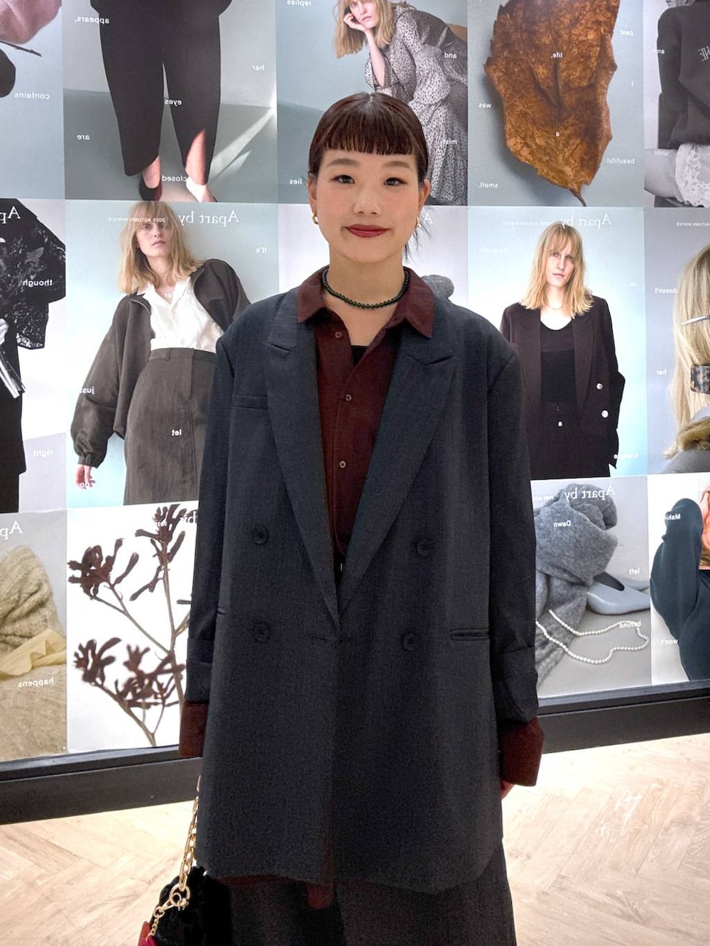 ブラック系のショルダーバッグ、グレー系のスカート、グレー系のテーラードジャケットを着用したレディースの秋コーディネートの6枚目の写真