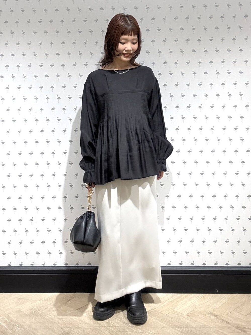 ブラック系のショルダーバッグ、ブラック系のシャツ/ブラウス、ホワイト系のスカートを着用したレディースの冬コーディネートの5枚目の写真