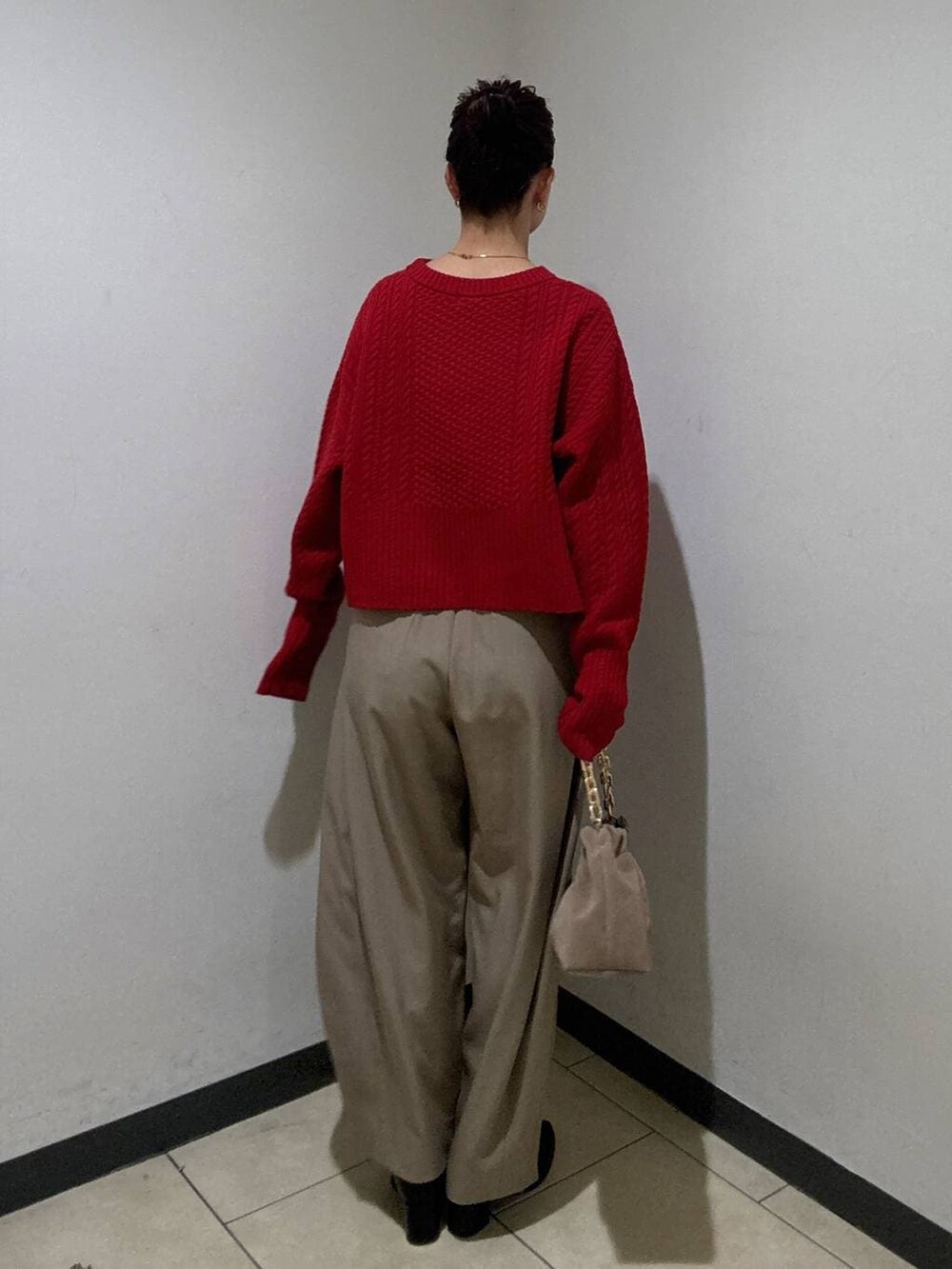 ベージュ系のスラックス、ブラック系のブーツ、ベージュ系のショルダーバッグを着用したレディースの冬コーディネートの4枚目の写真