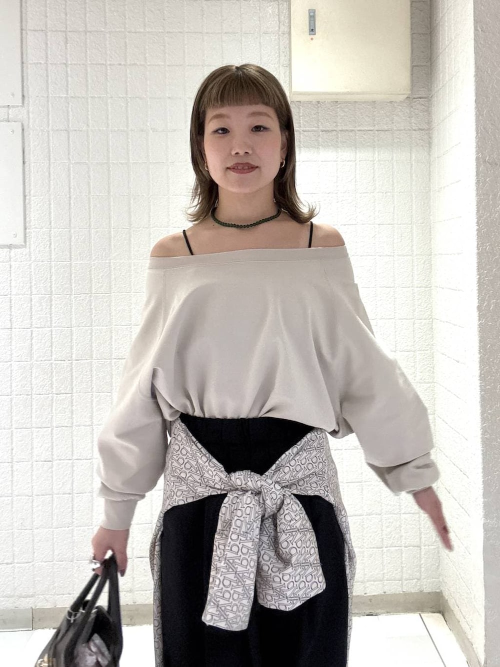 ブラック系のスラックス、ブラウン系のショルダーバッグ、ホワイト系のTシャツ/カットソーを着用したレディースの春コーディネートの6枚目の写真