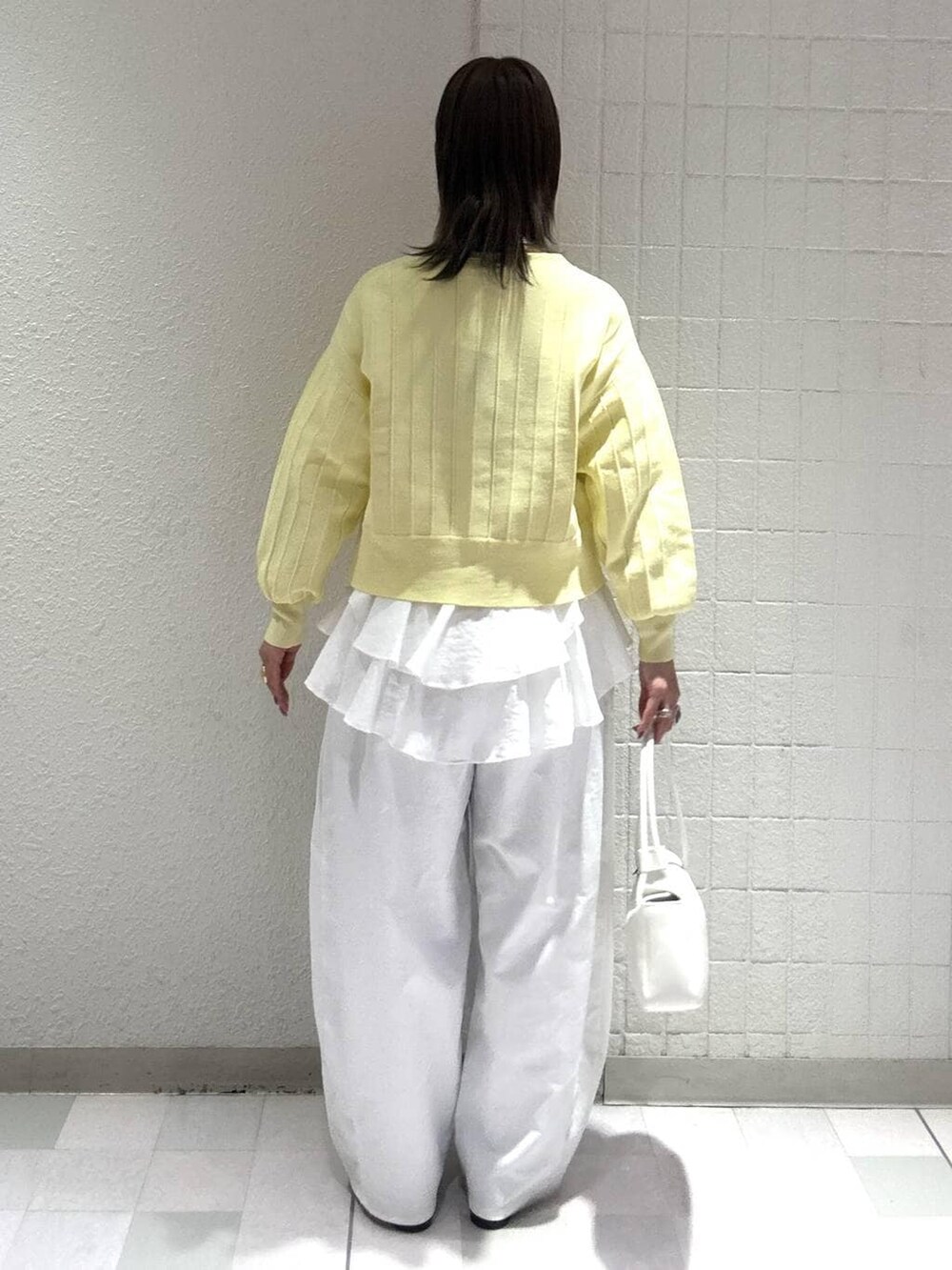 イエロー系のカーディガン/ボレロ、ホワイト系のシャツ/ブラウス、ホワイト系のショルダーバッグを着用したレディースの春コーディネートの3枚目の写真