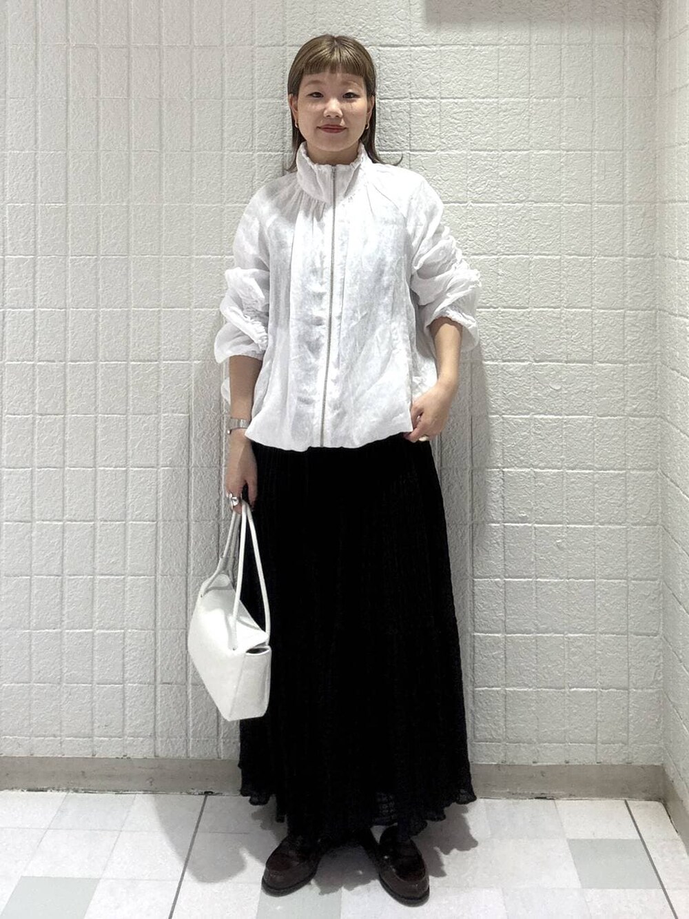 ホワイト系のショルダーバッグ、ホワイト系のブルゾン、ブラック系のワンピースを着用したレディースの春コーディネートの5枚目の写真