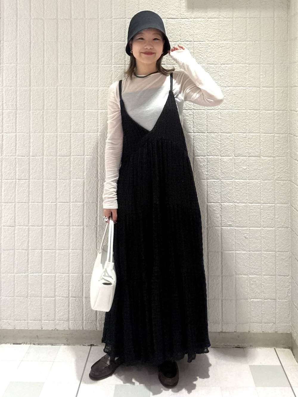 ホワイト系のTシャツ/カットソー、ホワイト系のショルダーバッグ、ブラック系のワンピースを着用したレディースの春コーディネートの2枚目の写真
