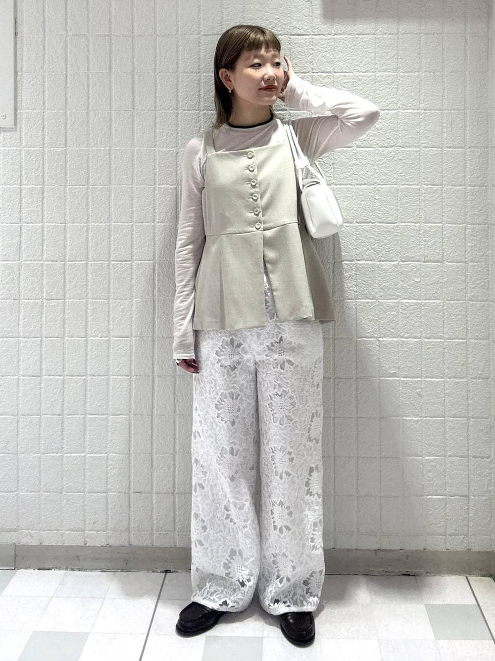 ベージュ系のベスト、ホワイト系のTシャツ/カットソー、ホワイト系のショルダーバッグを着用したレディースの春コーディネートの5枚目の写真