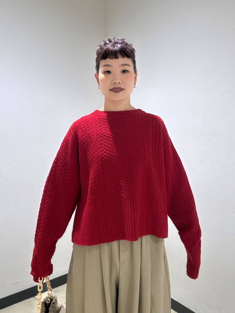 ベージュ系のスラックス、ブラック系のブーツ、ベージュ系のショルダーバッグを着用したレディースの冬コーディネートの6枚目の写真