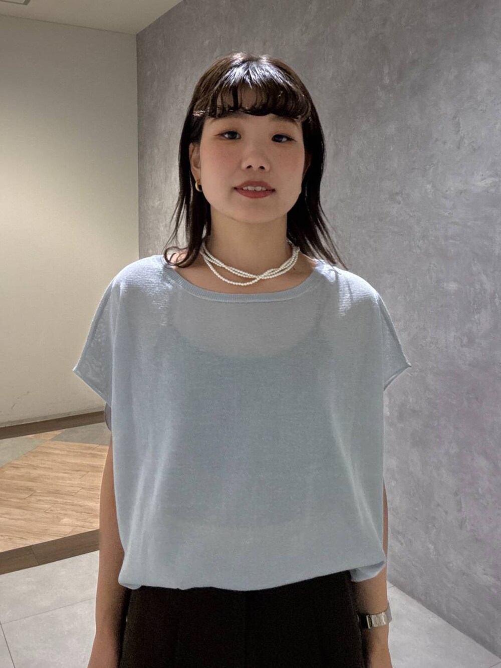 ブラック系のサンダル、ブラウン系のスラックス、ブルー系のニット/セーターを着用したレディースの夏コーディネートの5枚目の写真