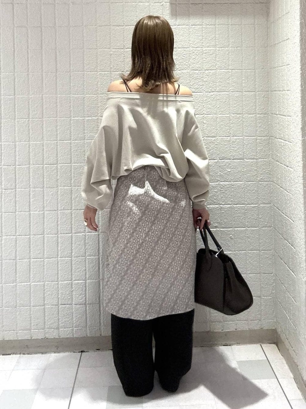 ブラック系のスラックス、ブラウン系のショルダーバッグ、ホワイト系のTシャツ/カットソーを着用したレディースの春コーディネートの5枚目の写真