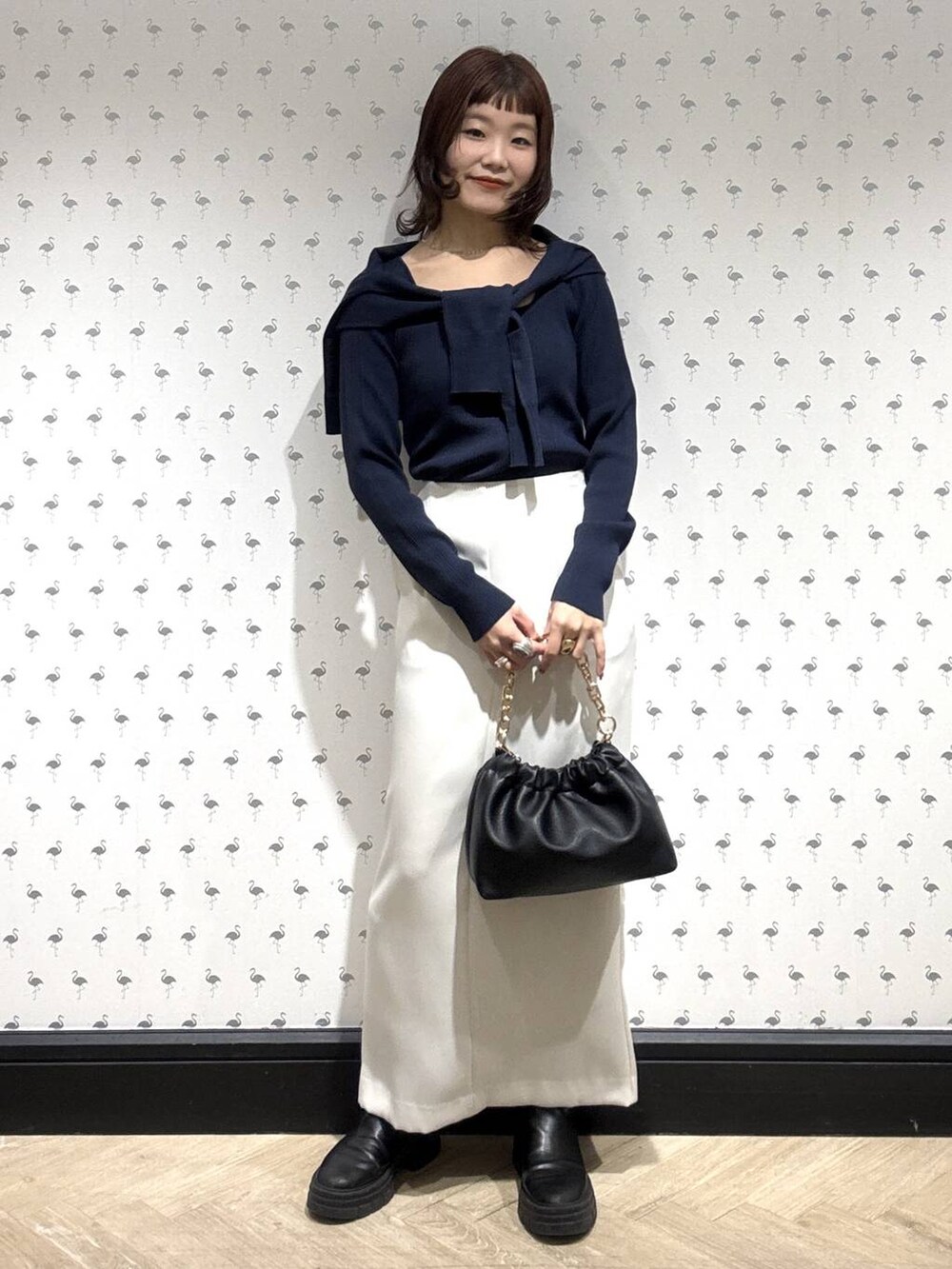 ブラック系のショルダーバッグ、ブルー系のカーディガン/ボレロ、ブルー系のニット/セーターを着用したレディースの冬コーディネートの2枚目の写真