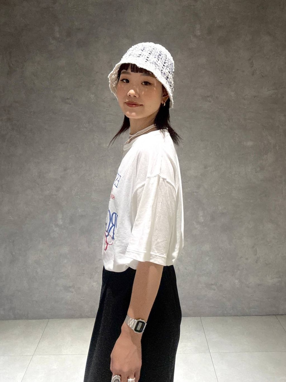 ブラック系のサンダル、ブラック系のスラックス、ホワイト系のTシャツ/カットソーを着用したレディースの夏コーディネートの6枚目の写真