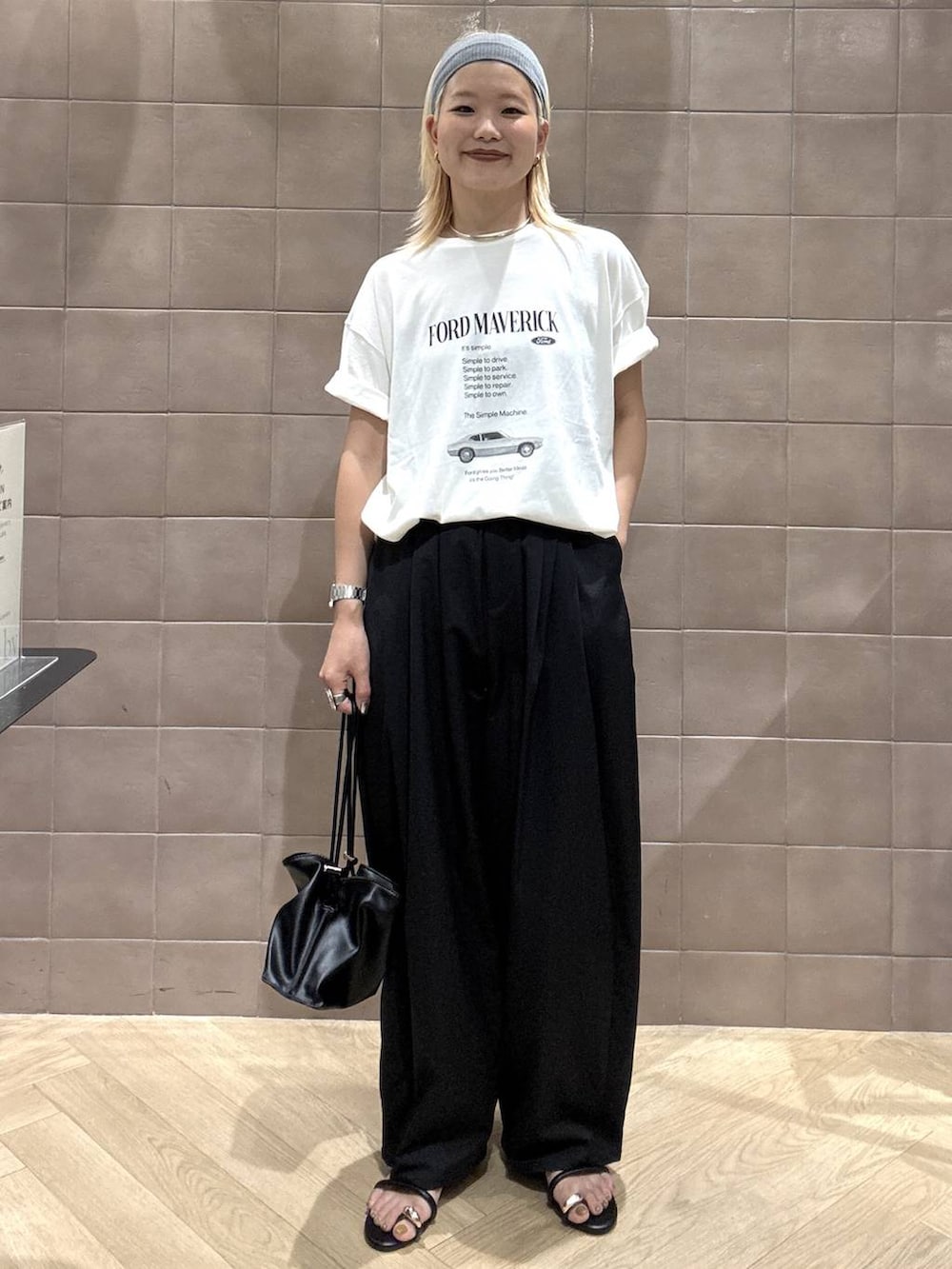 ブラック系のショルダーバッグ、ホワイト系のTシャツ/カットソー、ブラック系のサンダルを着用したレディースの夏コーディネートの6枚目の写真