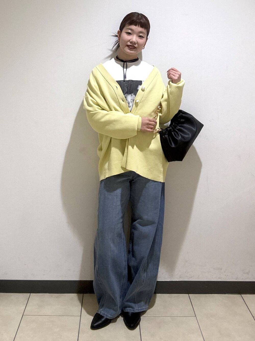 ブルー系のデニムパンツ、ブラック系のブーツ、イエロー系のカーディガン/ボレロを着用したレディースの冬コーディネートの5枚目の写真