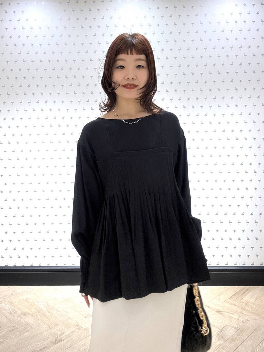 ブラック系のショルダーバッグ、ブラック系のシャツ/ブラウス、ホワイト系のスカートを着用したレディースの冬コーディネートの6枚目の写真