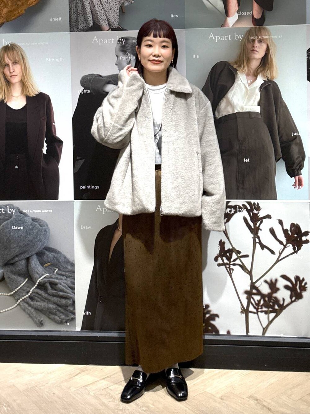 ブラック系のローファー、ブラウン系のスカート、ホワイト系のTシャツ/カットソーを着用したレディースの秋コーディネートの5枚目の写真