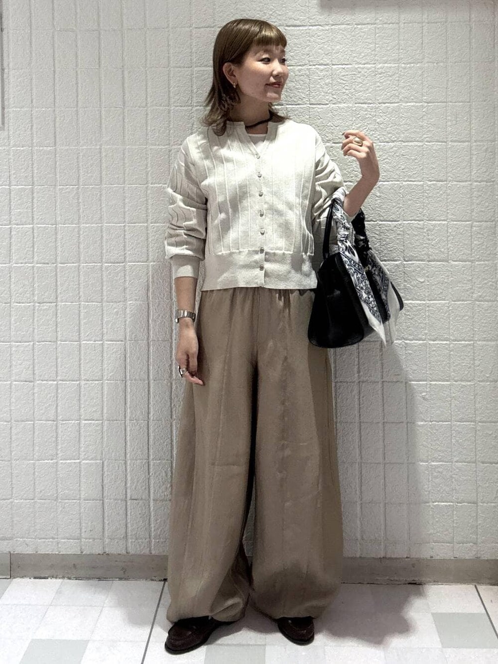 ホワイト系のカーディガン/ボレロ、ベージュ系のその他パンツ、ブラック系のショルダーバッグを着用したレディースの春コーディネートの2枚目の写真