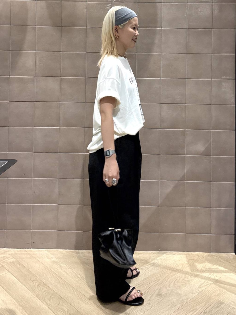 ブラック系のショルダーバッグ、ホワイト系のTシャツ/カットソー、ブラック系のサンダルを着用したレディースの夏コーディネートの4枚目の写真