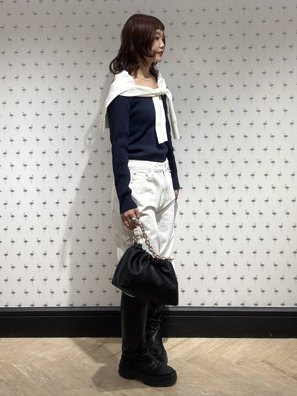 ブラック系のショルダーバッグ、ホワイト系のデニムパンツ、ホワイト系のカーディガン/ボレロを着用したレディースの冬コーディネートの3枚目の写真