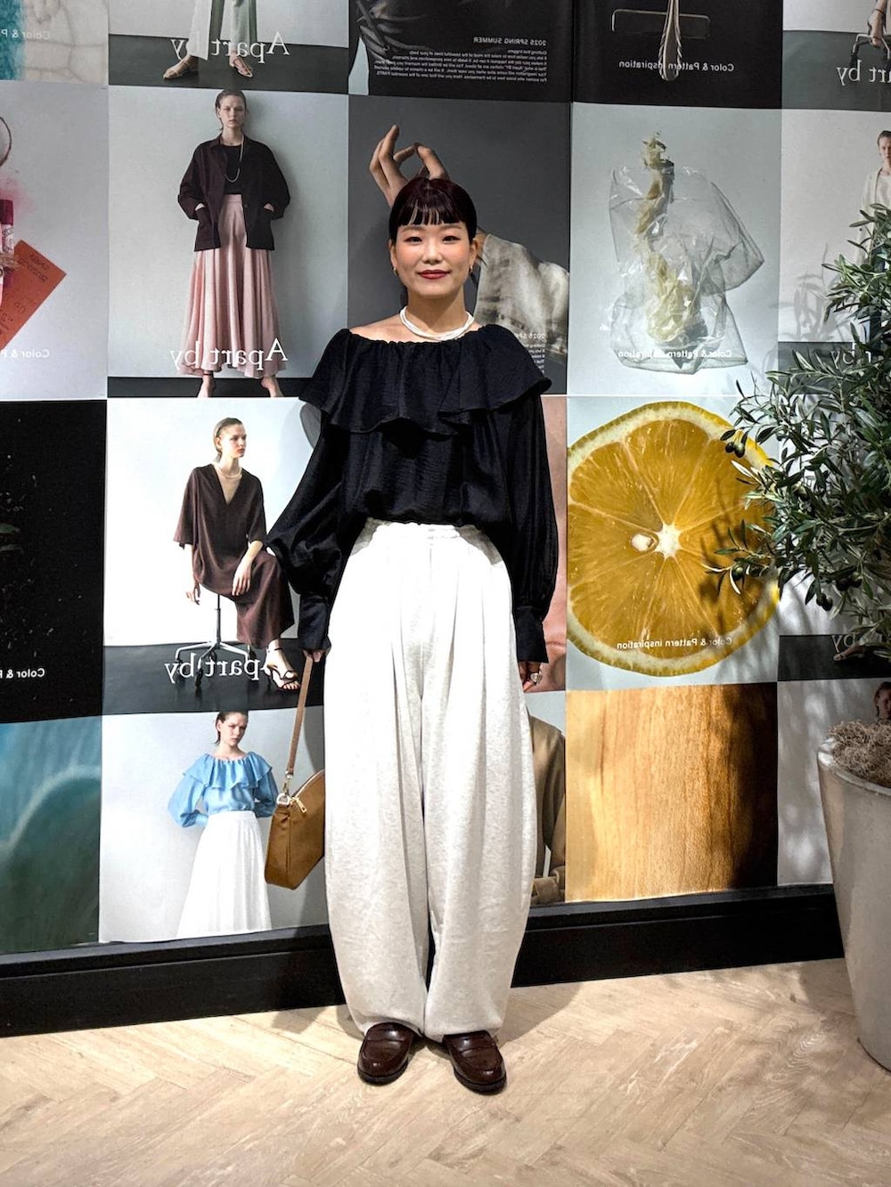 ブラック系のシャツ/ブラウス、グレー系のスウェットパンツ、イエロー系のショルダーバッグを着用したレディースの夏コーディネートの4枚目の写真