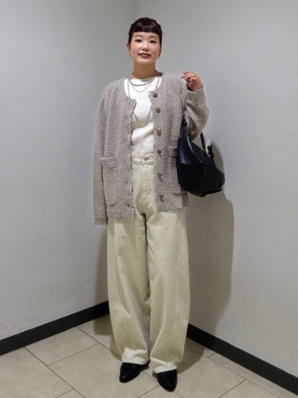 ベージュ系のデニムパンツ、ブラック系のブーツ、ホワイト系のニット/セーターを着用したレディースの秋コーディネートの4枚目の写真