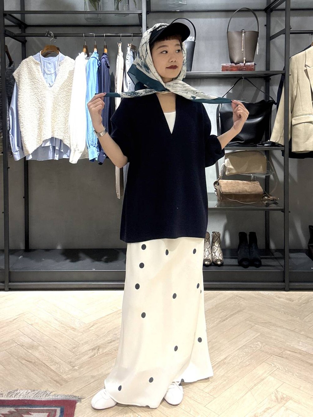 ホワイト系のスニーカー、ブルー系のニット/セーター、ホワイト系のスカートを着用したレディースの冬コーディネートの6枚目の写真