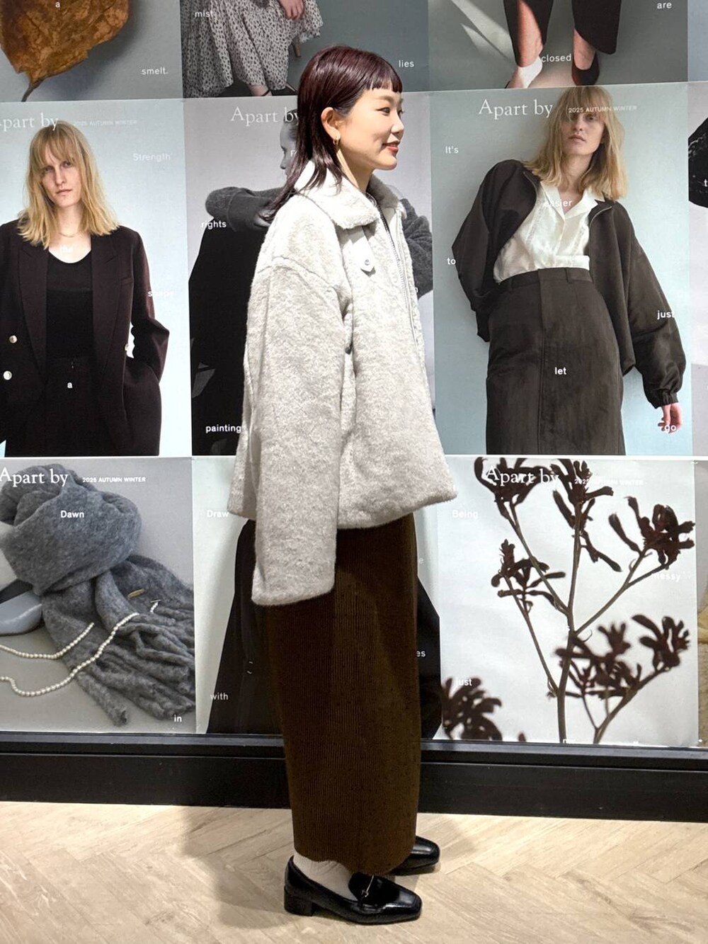 ブラック系のローファー、ブラウン系のスカート、ホワイト系のTシャツ/カットソーを着用したレディースの秋コーディネートの3枚目の写真