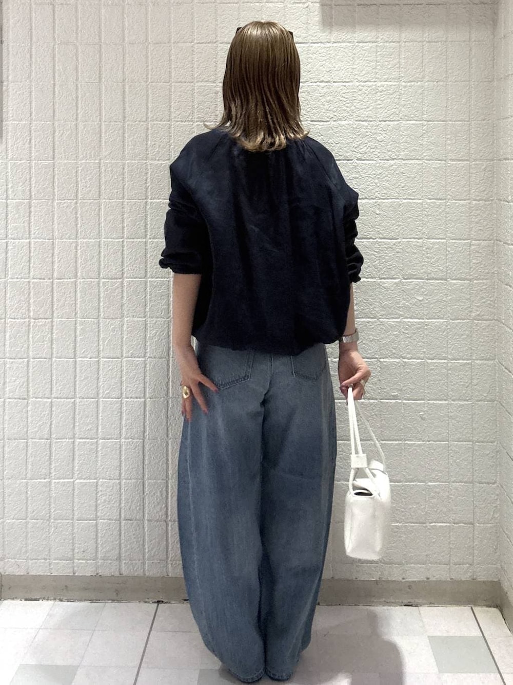 ブルー系のデニムパンツ、ホワイト系のショルダーバッグ、ブルー系のブルゾンを着用したレディースの春コーディネートの4枚目の写真