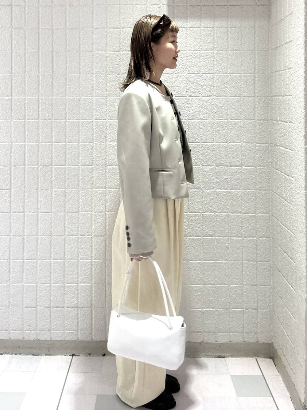 ホワイト系のショルダーバッグ、ベージュ系のカーディガン/ボレロ、ベージュ系のノーカラージャケットを着用したレディースの春コーディネートの3枚目の写真