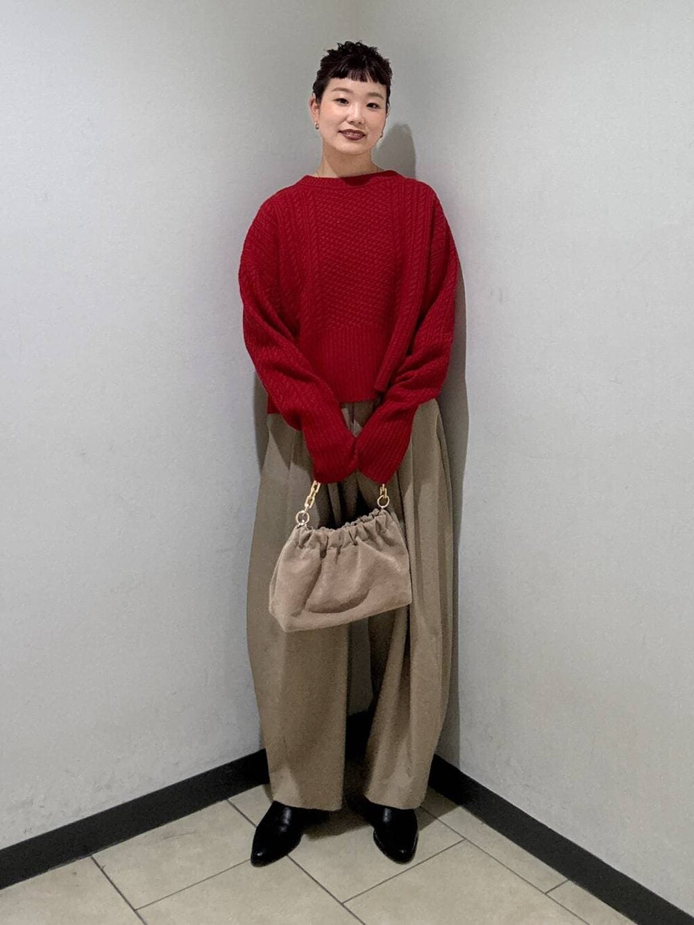 ベージュ系のスラックス、ブラック系のブーツ、ベージュ系のショルダーバッグを着用したレディースの冬コーディネートの5枚目の写真