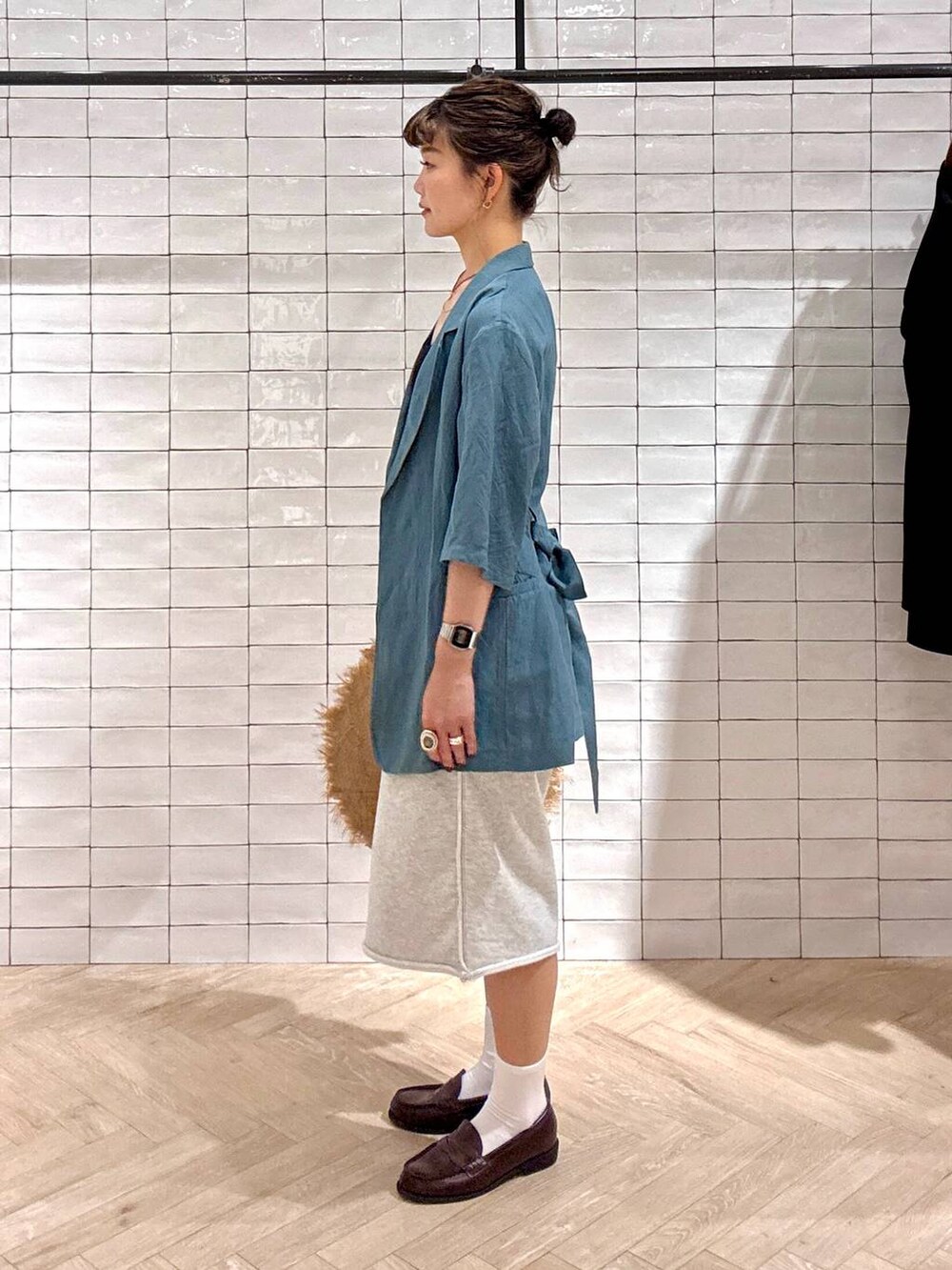 グリーン系のテーラードジャケット、グレー系のスウェットパンツ、ゴールド系のネックレスを着用したレディースの春コーディネートの2枚目の写真