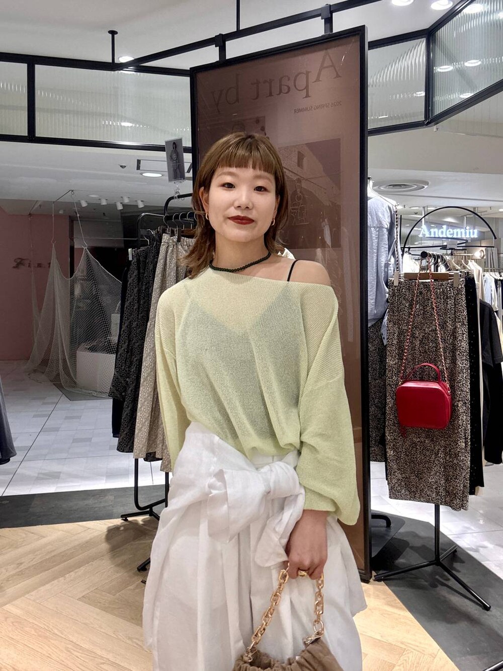 ホワイト系のシャツ/ブラウス、ベージュ系のショルダーバッグ、グリーン系のニット/セーターを着用したレディースの春コーディネートの5枚目の写真