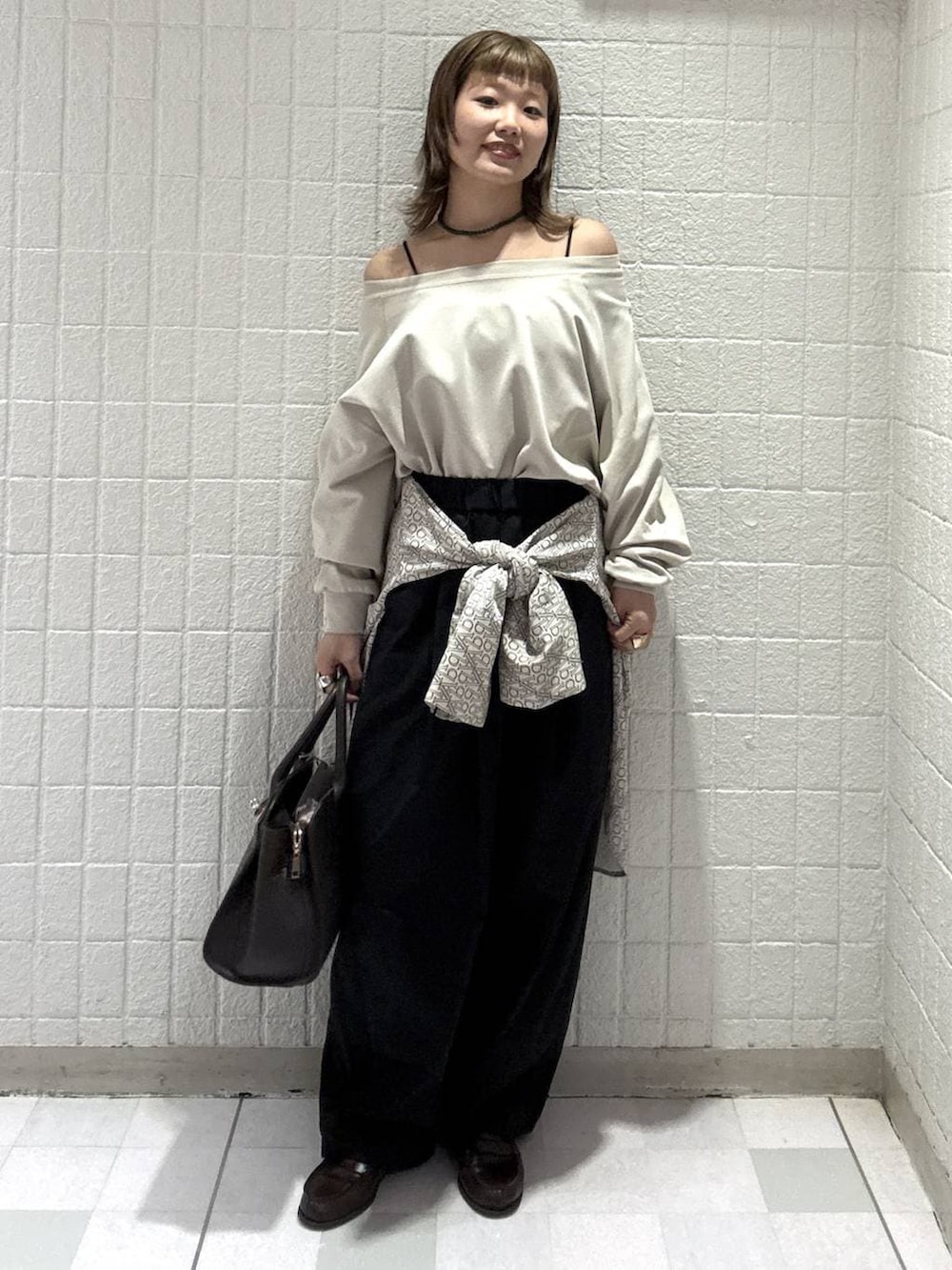 ブラック系のスラックス、ブラウン系のショルダーバッグ、ホワイト系のTシャツ/カットソーを着用したレディースの春コーディネートの4枚目の写真