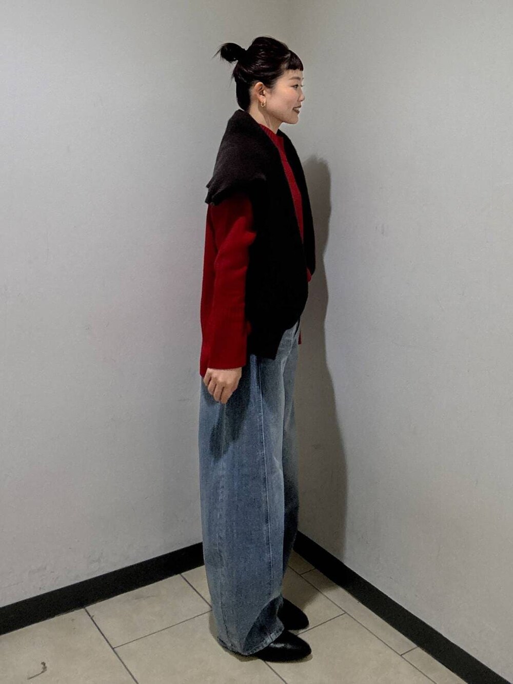 ブルー系のデニムパンツ、ブラック系のブーツ、レッド系のニット/セーターを着用したレディースの冬コーディネートの3枚目の写真