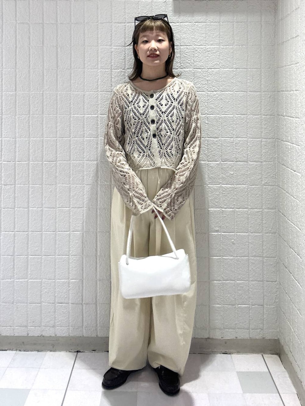 ホワイト系のショルダーバッグ、ベージュ系のカーディガン/ボレロ、ブラウン系のサングラスを着用したレディースの春コーディネートの5枚目の写真
