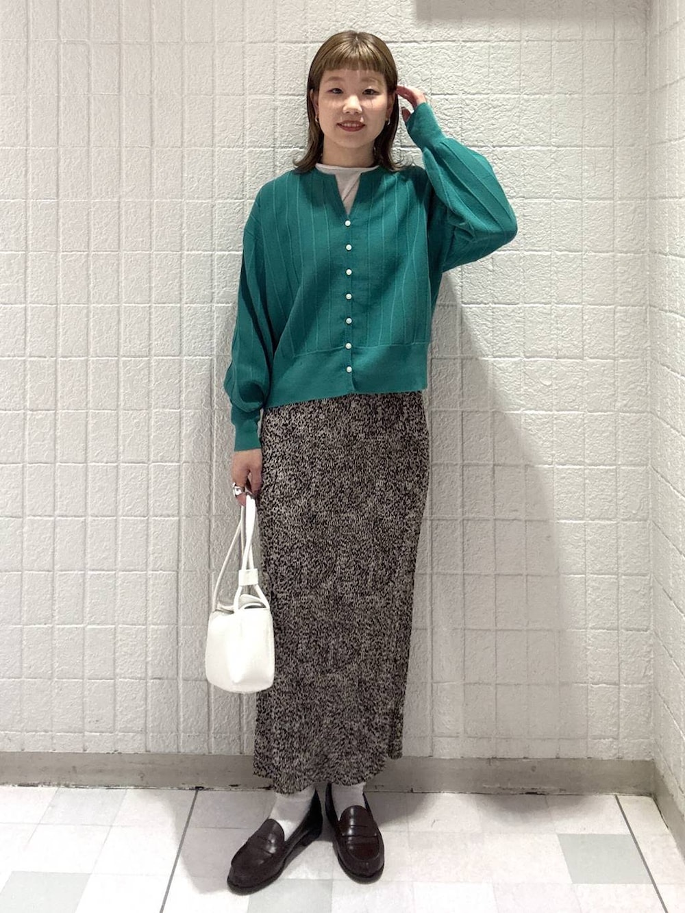 グリーン系のカーディガン/ボレロ、ブラウン系のスカート、ホワイト系のショルダーバッグを着用したレディースの春コーディネートの5枚目の写真