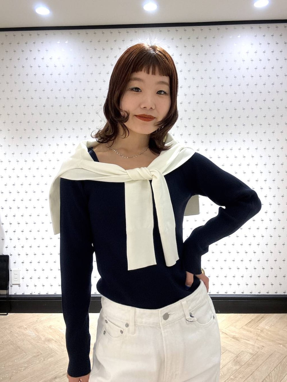 ブラック系のショルダーバッグ、ホワイト系のデニムパンツ、ホワイト系のカーディガン/ボレロを着用したレディースの冬コーディネートの6枚目の写真