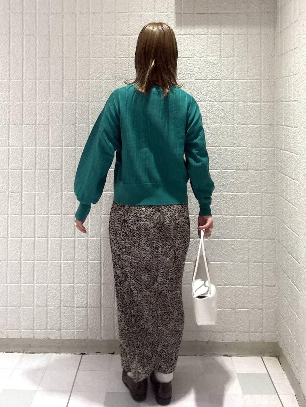 グリーン系のカーディガン/ボレロ、ブラウン系のスカート、ホワイト系のショルダーバッグを着用したレディースの春コーディネートの4枚目の写真