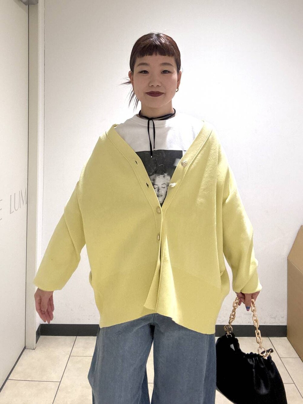 ブルー系のデニムパンツ、ブラック系のブーツ、イエロー系のカーディガン/ボレロを着用したレディースの冬コーディネートの6枚目の写真