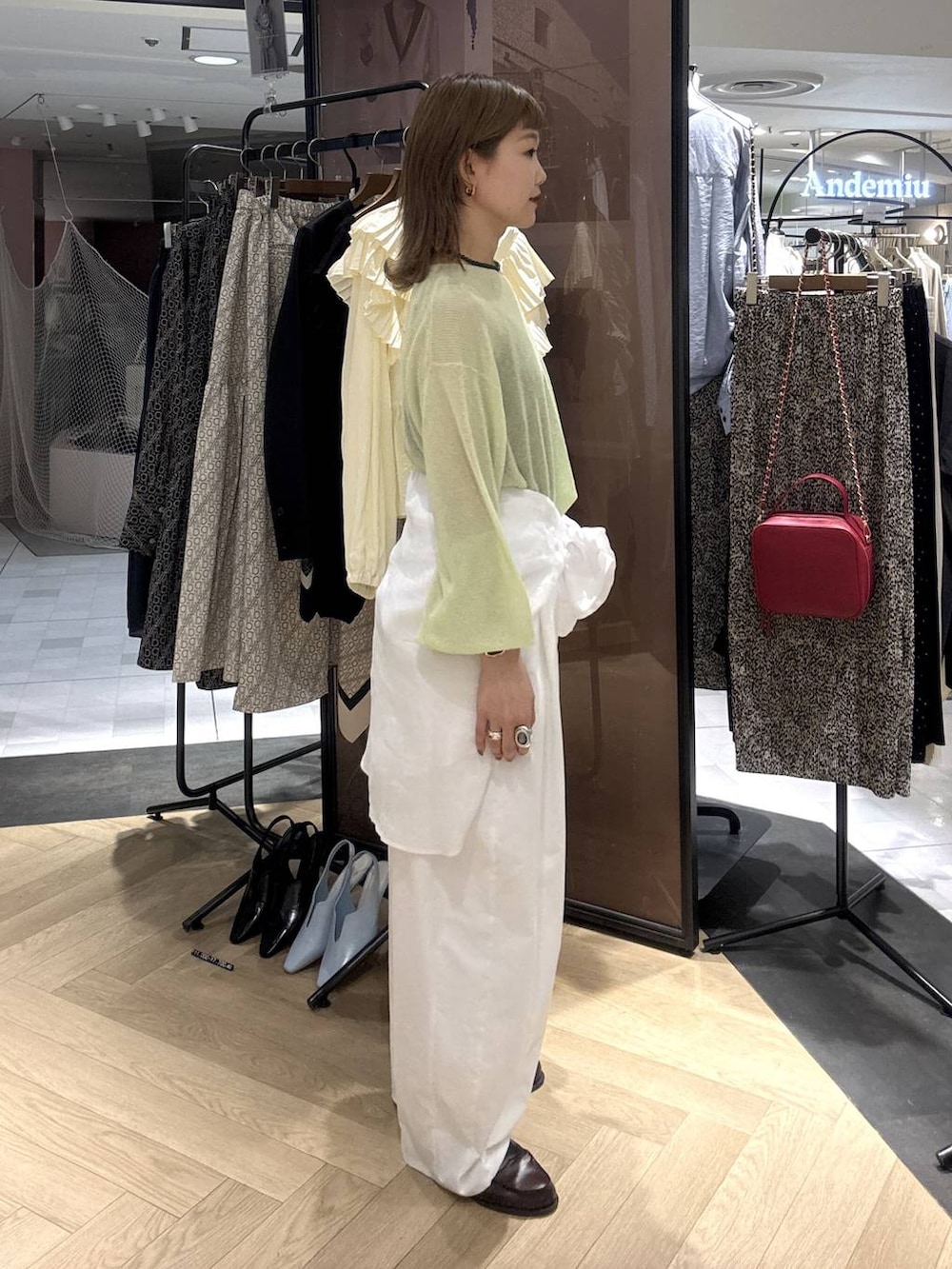 ホワイト系のシャツ/ブラウス、ベージュ系のショルダーバッグ、グリーン系のニット/セーターを着用したレディースの春コーディネートの4枚目の写真