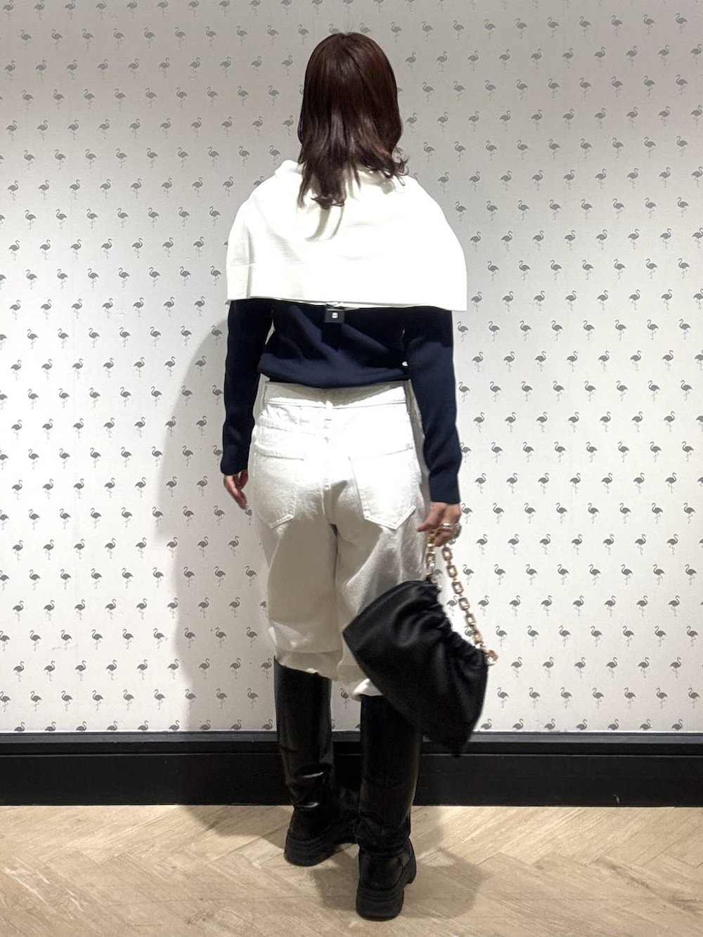 ブラック系のショルダーバッグ、ホワイト系のデニムパンツ、ホワイト系のカーディガン/ボレロを着用したレディースの冬コーディネートの4枚目の写真