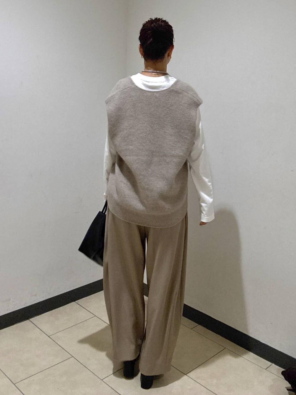 ベージュ系のスラックス、ブラック系のブーツ、ホワイト系のTシャツ/カットソーを着用したレディースの秋コーディネートの4枚目の写真