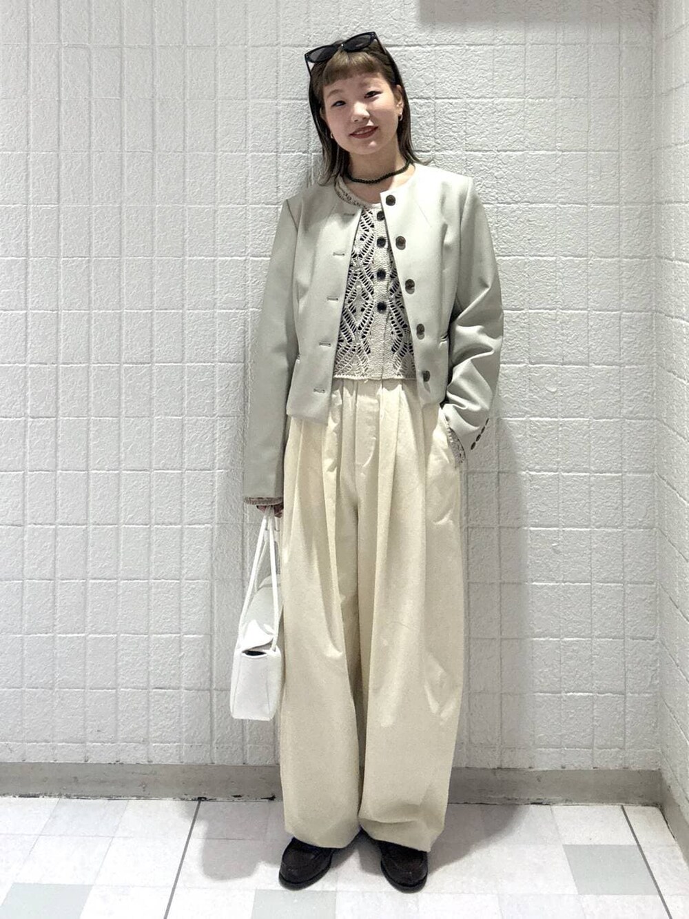 ホワイト系のショルダーバッグ、ベージュ系のカーディガン/ボレロ、ベージュ系のノーカラージャケットを着用したレディースの春コーディネートの5枚目の写真