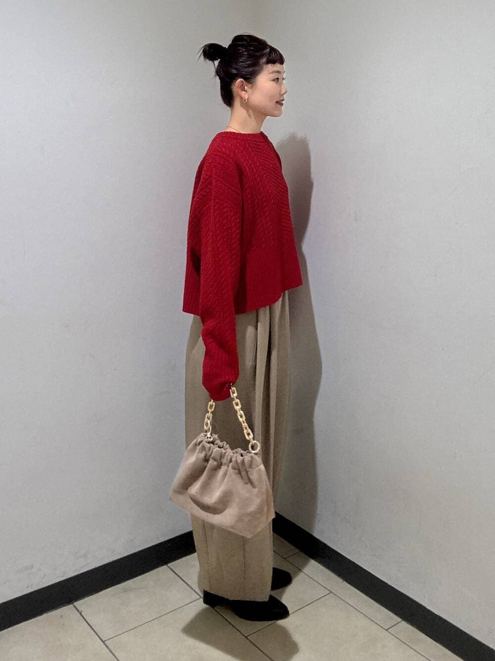 ベージュ系のスラックス、ブラック系のブーツ、ベージュ系のショルダーバッグを着用したレディースの冬コーディネートの3枚目の写真