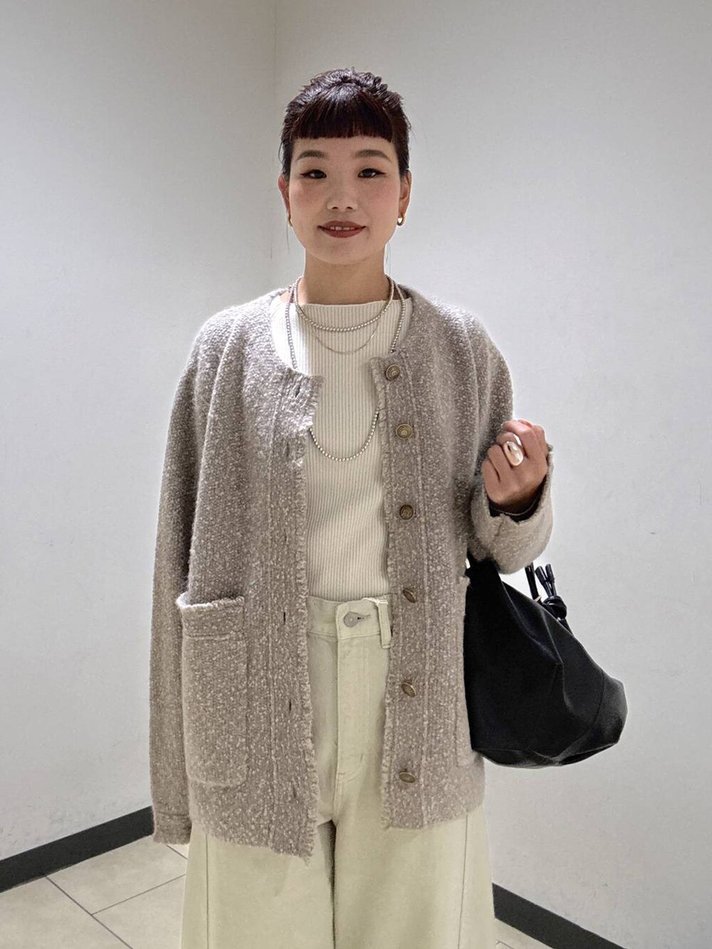 ベージュ系のデニムパンツ、ブラック系のブーツ、ホワイト系のニット/セーターを着用したレディースの秋コーディネートの5枚目の写真