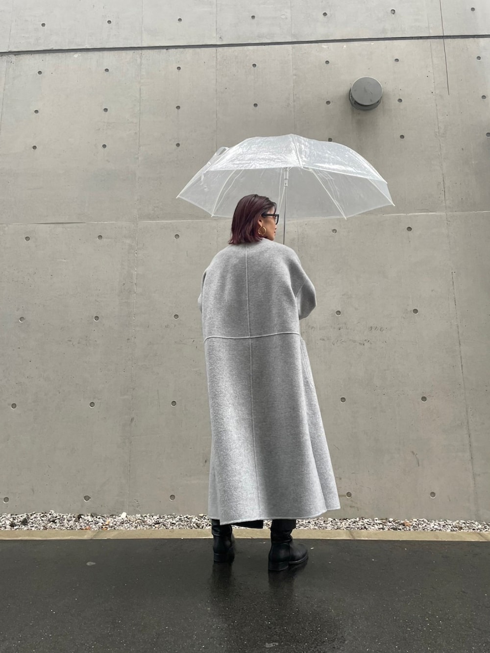 グレー系のノーカラーコートを着用したレディースの秋コーディネートの4枚目の写真