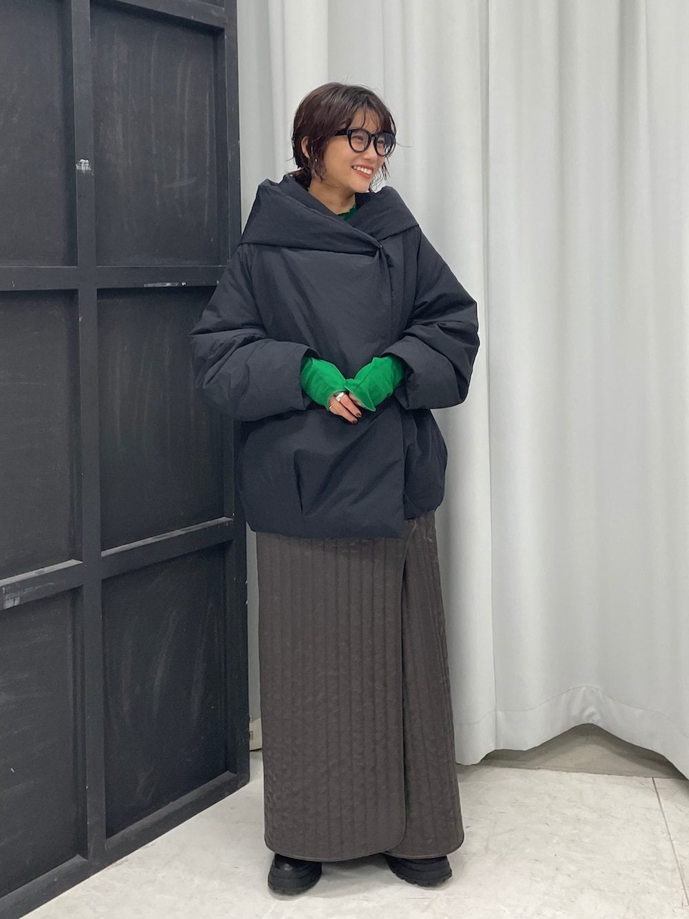 ブラック系のダウンジャケット/コート、グリーン系のTシャツ/カットソー、グリーン系のスカートを着用したレディースの秋コーディネートの3枚目の写真